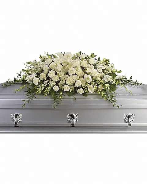 White floral casket spray on a silver casket