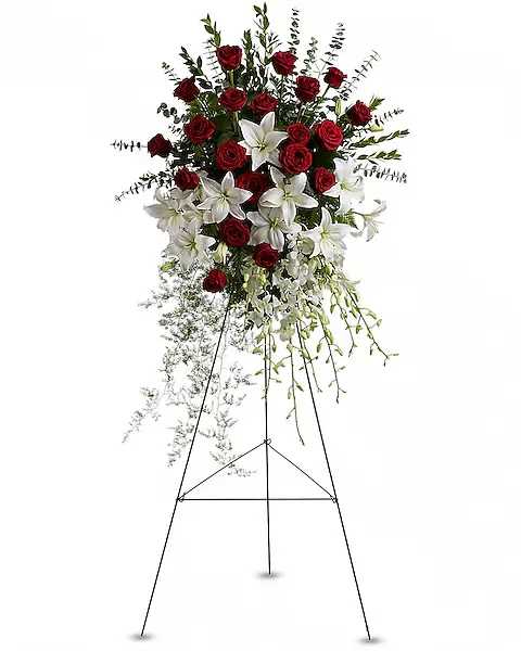 Standing floral spray with red roses and white lilies on an easel