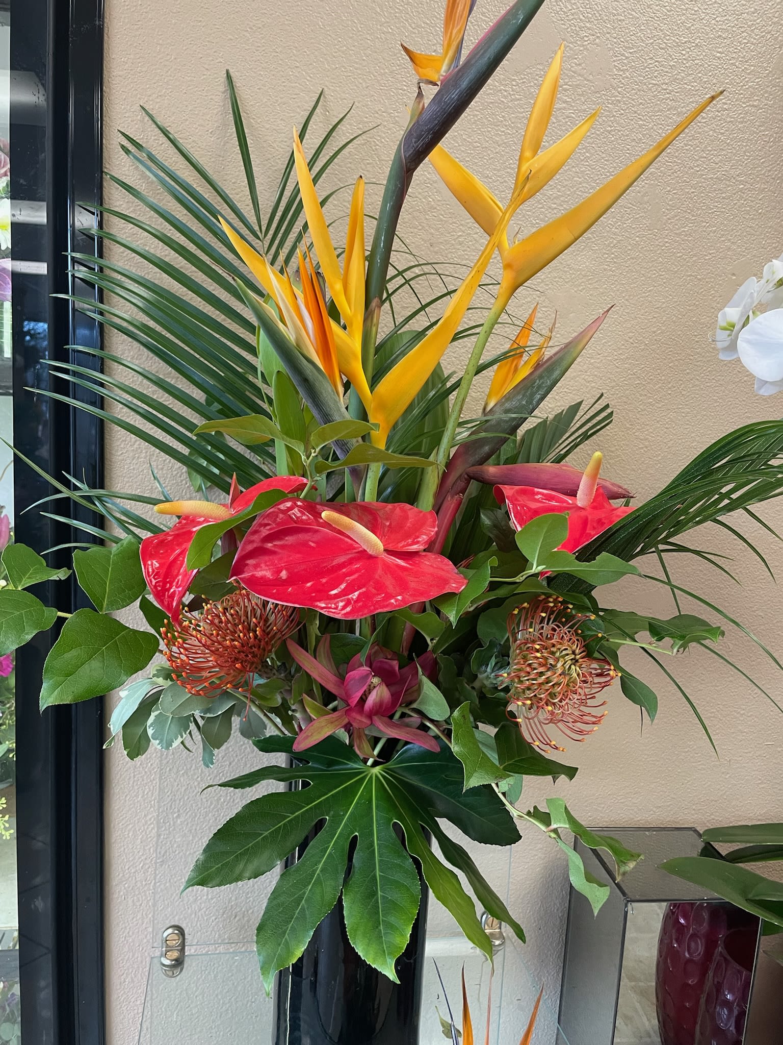 Tropical arrangement with red anthuriums and yellow bird of paradise