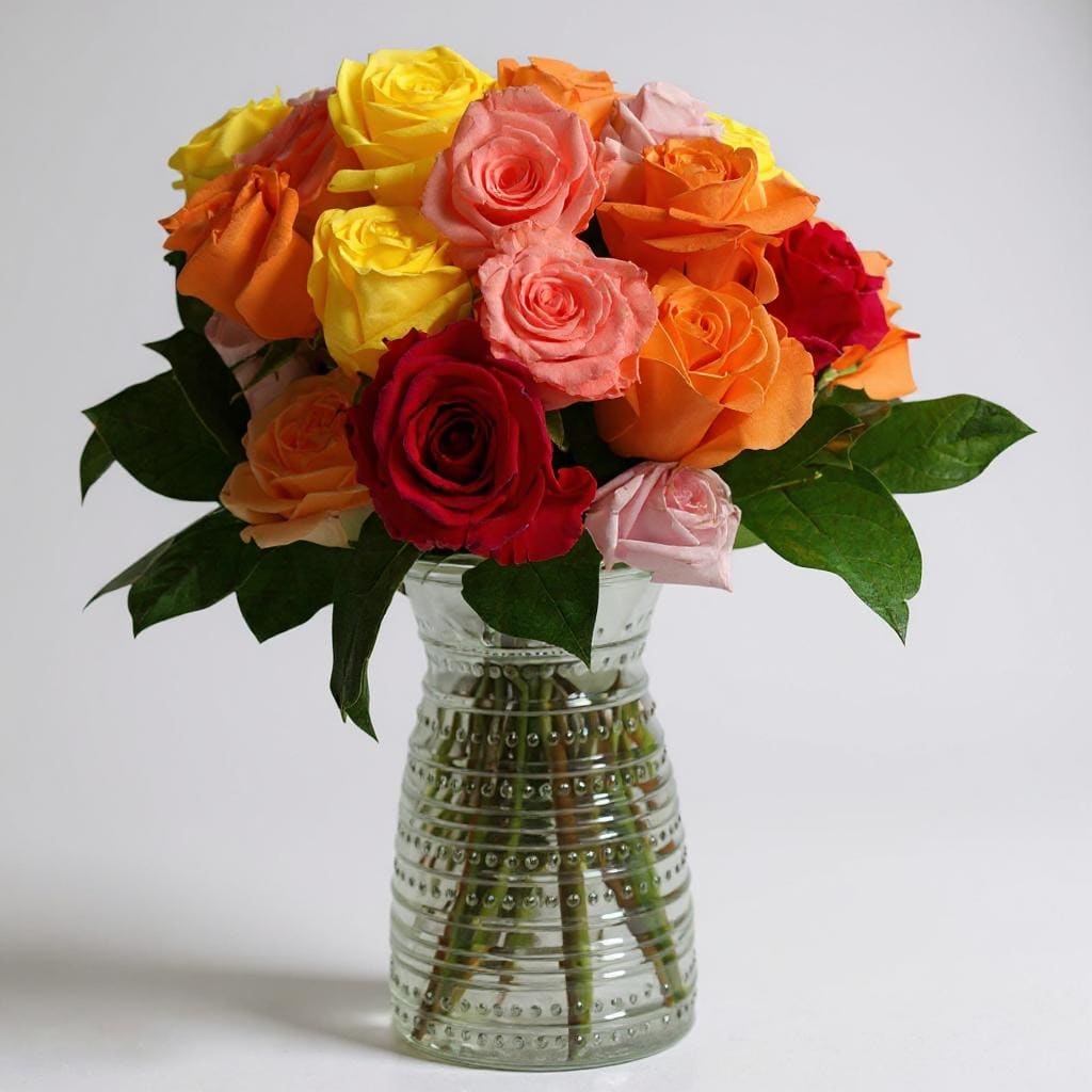 Roseplosion! - Bold, bright, and bursting with color — Roseplosion is a stunning explosion of roses in every shade of passion. Featuring a dazzling mix of red, orange, pink, and coral roses, this arrangement is accented with fresh lemon leaf for a lush, polished finish. Whether you're celebrating love, life, or just making a statement, Roseplosion delivers maximum impact with timeless beauty and vibrant energy.  Vase Subject to Change