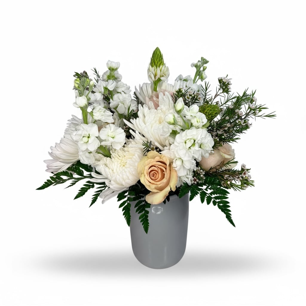 White floral arrangement in a gray vase with a peach rose