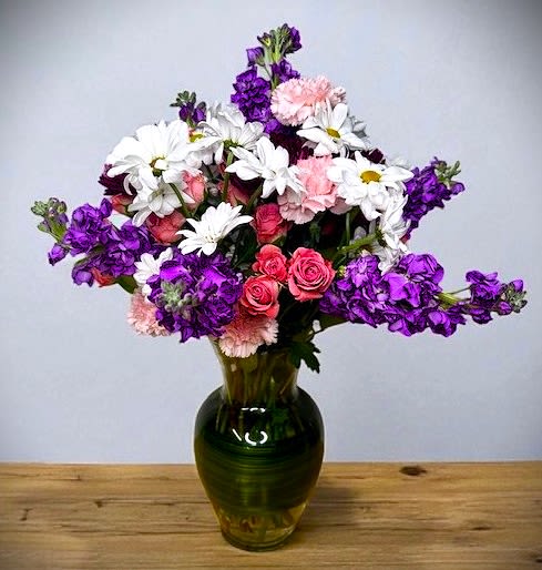 Garden Glory - Step into a world of blooming beauty with Garden Glory—a cheerful, garden-fresh arrangement that radiates charm and color. Featuring a lovely mix of pink spray roses, white daisies, classic carnations, and fragrant purple stock, this bouquet captures the effortless grace of an English garden in full bloom.  With soft textures and a soothing palette of pinks, whites, and purples, Garden Glory is perfect for celebrating birthdays, sending warm wishes, or simply adding a touch of natural joy to any space.  Whimsical. Welcoming. Wonderfully fresh.  Vase Subject to Change