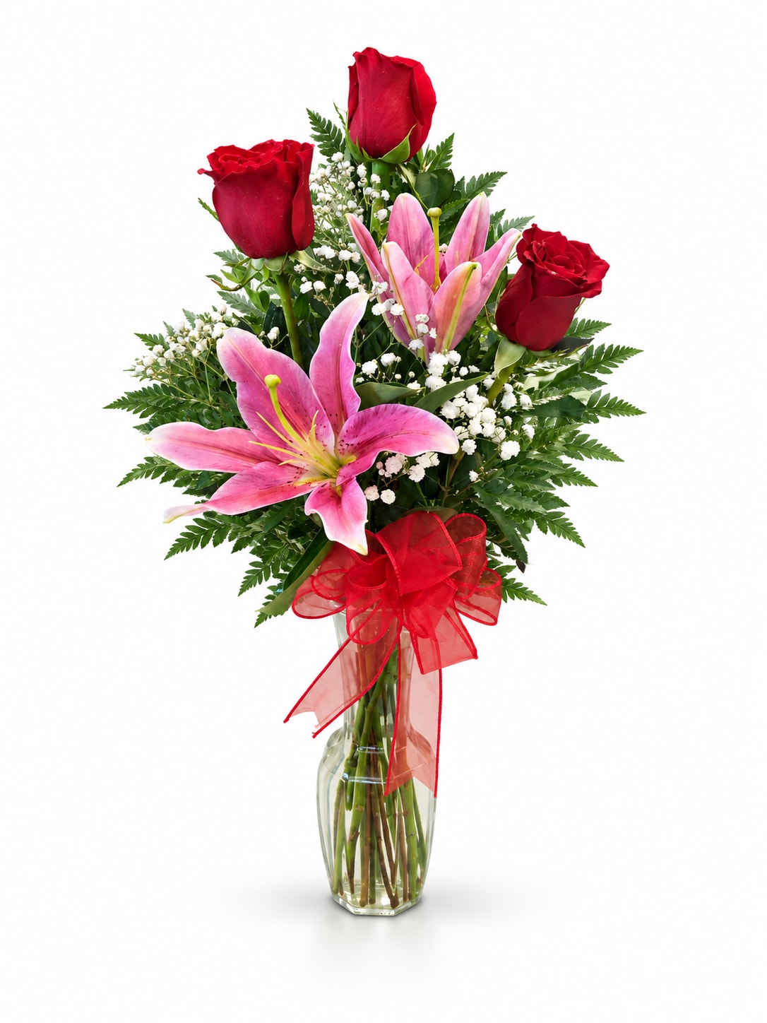 Red roses and pink lilies in a clear glass vase with a red bow