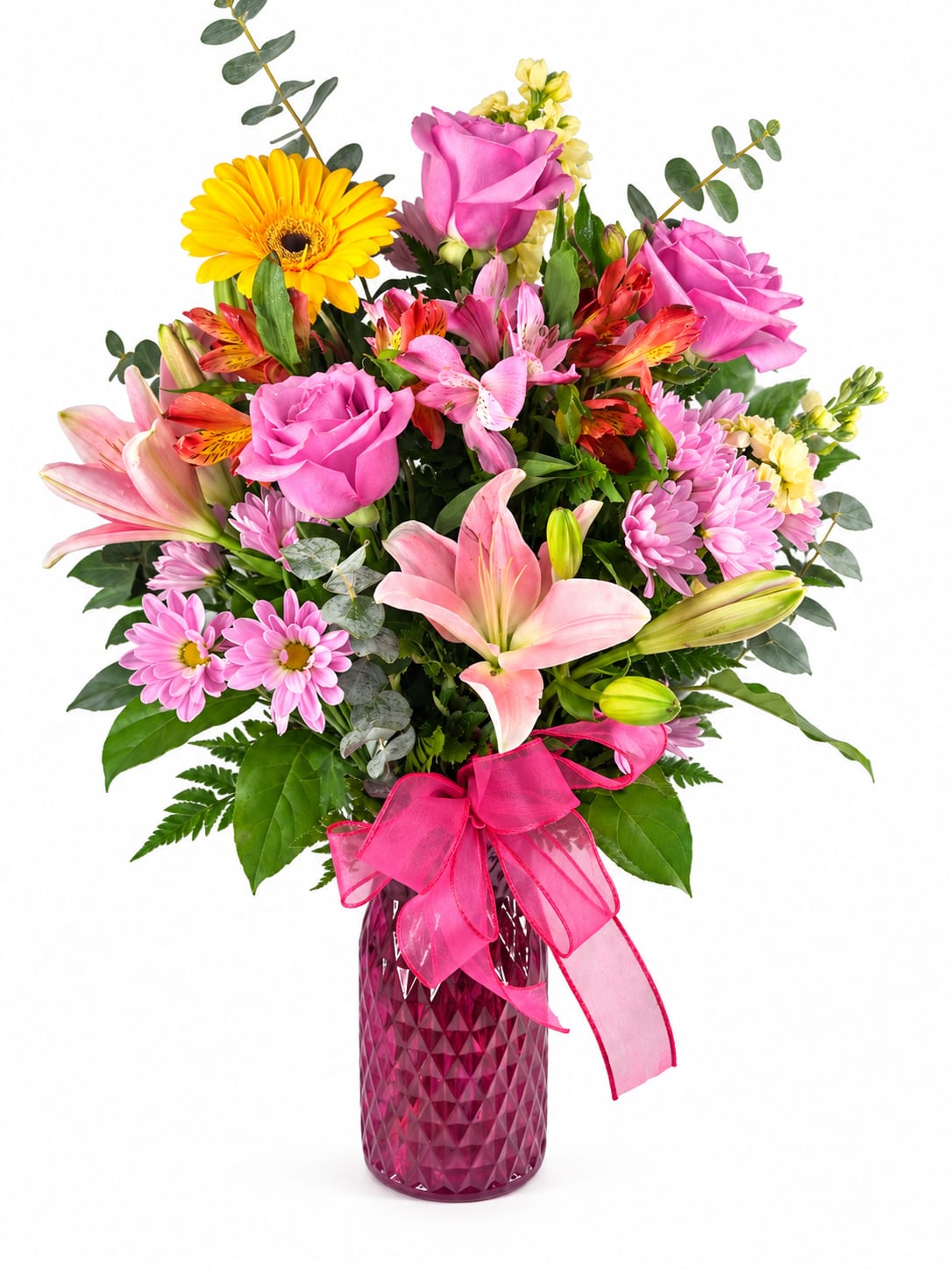 Mixed bouquet of pink and yellow flowers in a magenta vase with a pink ribbon
