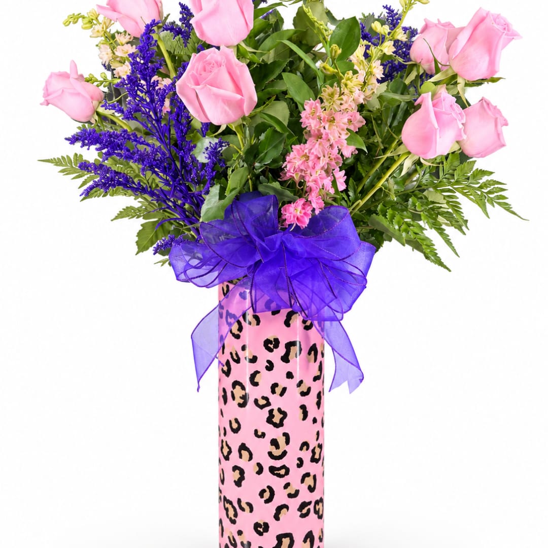 Pink roses and purple flowers in a decorated pink vase with a purple bow