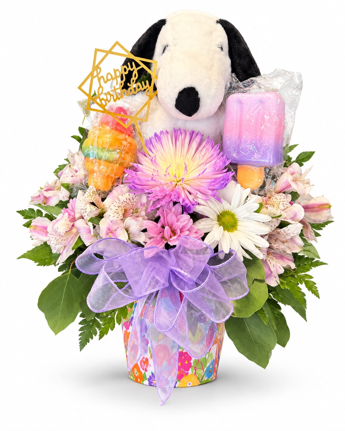 Birthday bouquet with a plush dog, flowers, and colorful candles in a decorated pot