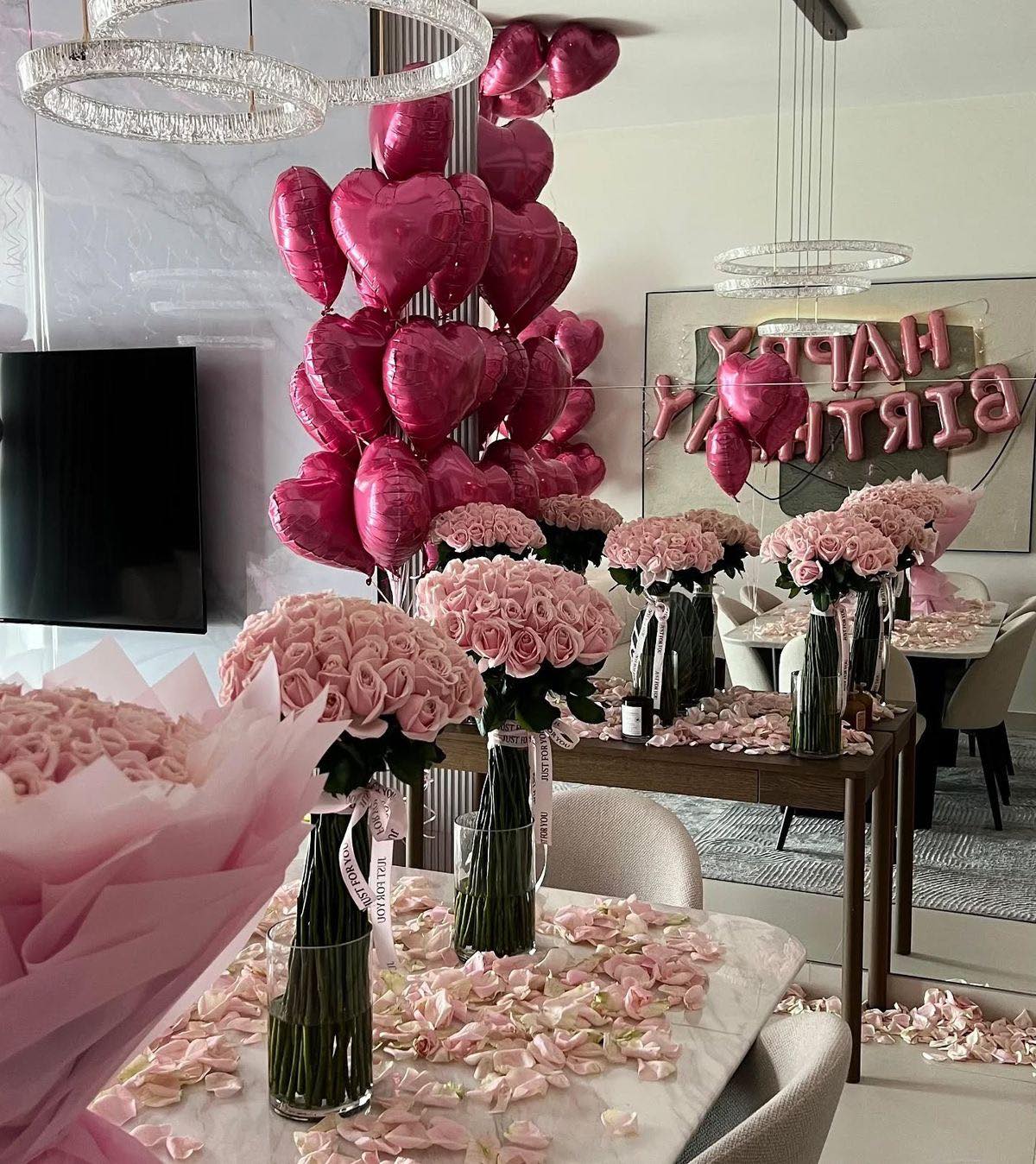 Pink rose bouquets with heart balloons in a decorated room