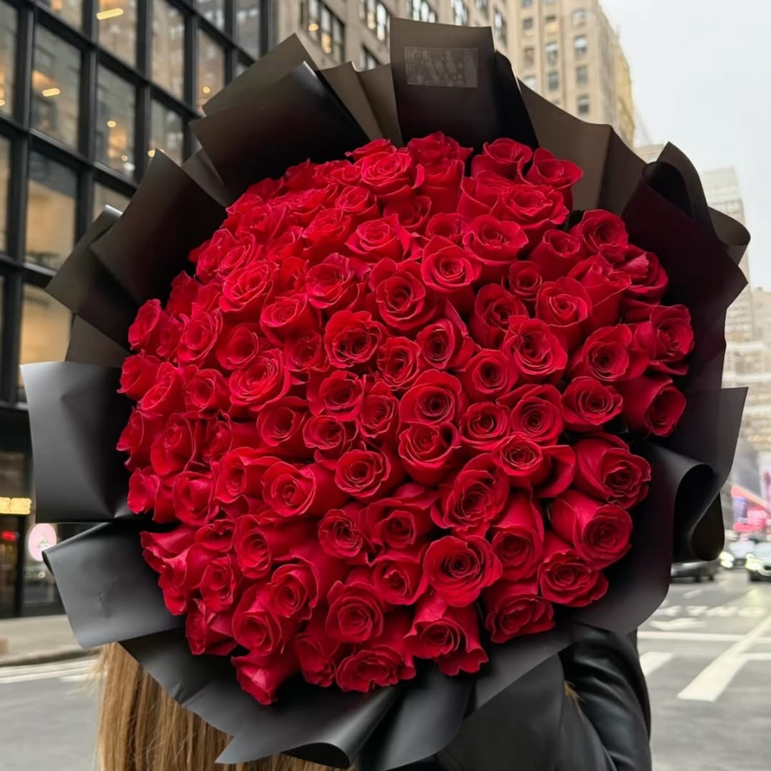 Large bouquet of red roses wrapped in black paper
