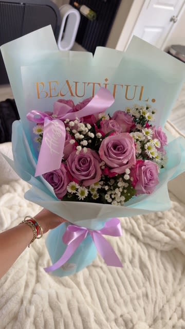 Bouquet of pink and lavender roses with small white filler flowers