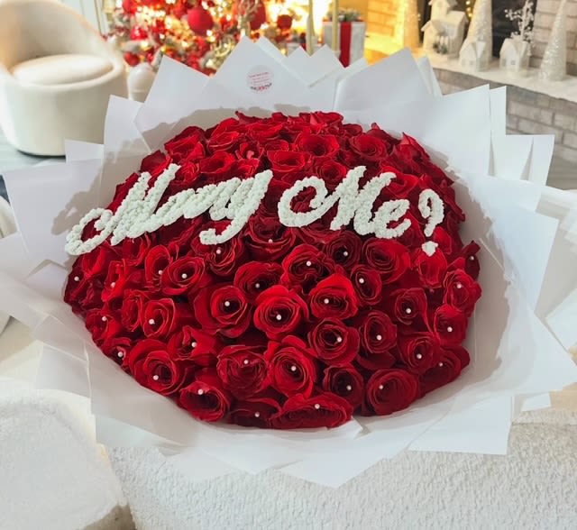 Large bouquet of red roses with white "Marry Me!" lettering