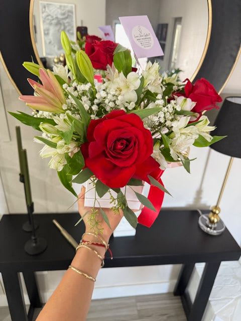 Bouquet of red roses and white lilies with baby's breath in a white box
