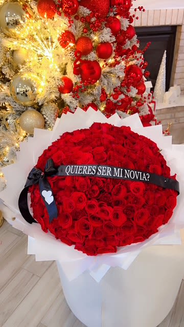 Large bouquet of red roses with a black ribbon and Spanish text band