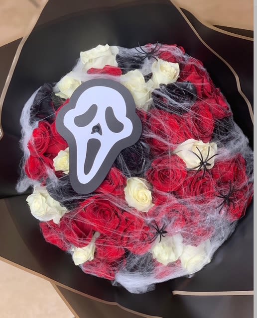 Screaming Roses - Unleash spooky elegance with Screaming Roses. This hauntingly beautiful bouquet features deep red, black, and ivory roses wrapped in eerie cobwebs and crawling spiders. Topped with the iconic Ghostface cutout, it's the perfect floral fright for Halloween lovers or horror movie fans.   Ideal for: Halloween gifts, horror fans, spooky romance  3 dozen roses