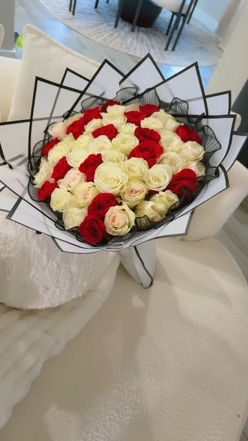 Bouquet of red and white roses wrapped in black and white paper