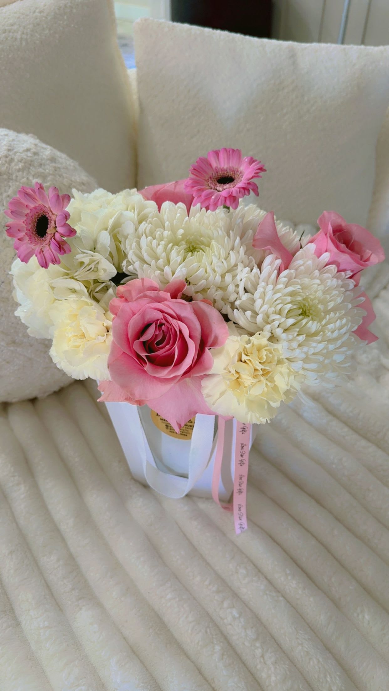 Pink and white bouquet with roses, chrysanthemums, and gerbera daisies in a white container