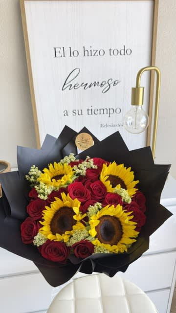 Bouquet of red roses and yellow sunflowers wrapped in black paper