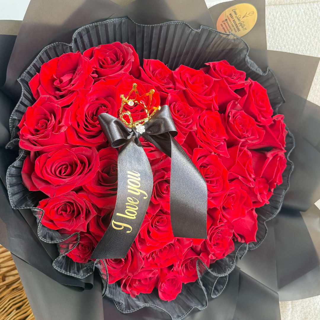 Bouquet of red roses wrapped in black paper with a ribbon