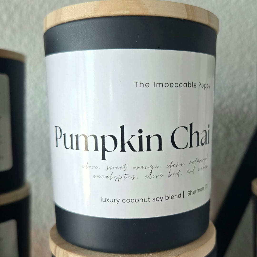 Black candle jar with a wood lid labeled Pumpkin Chai