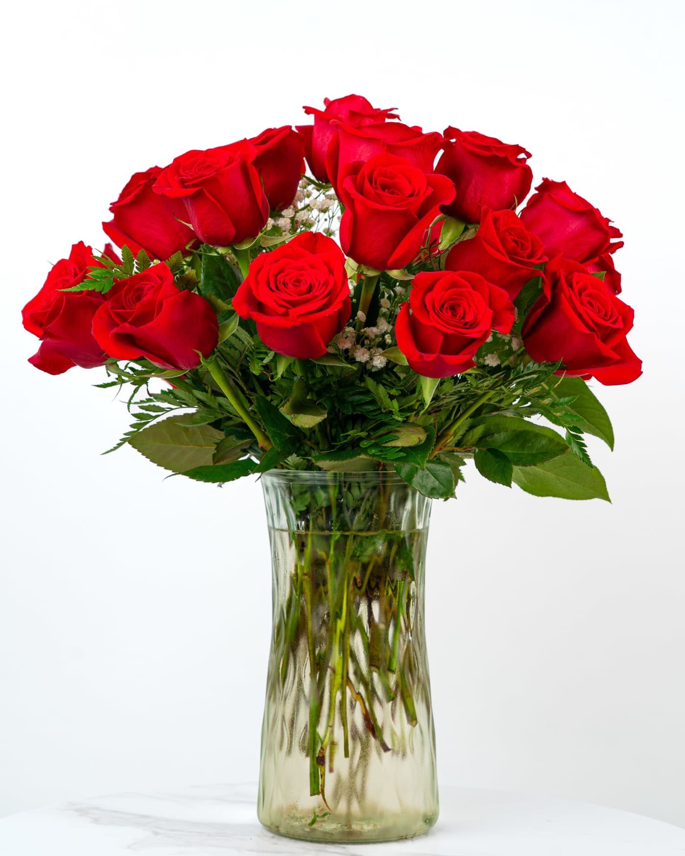 Red roses arranged in a clear glass vase