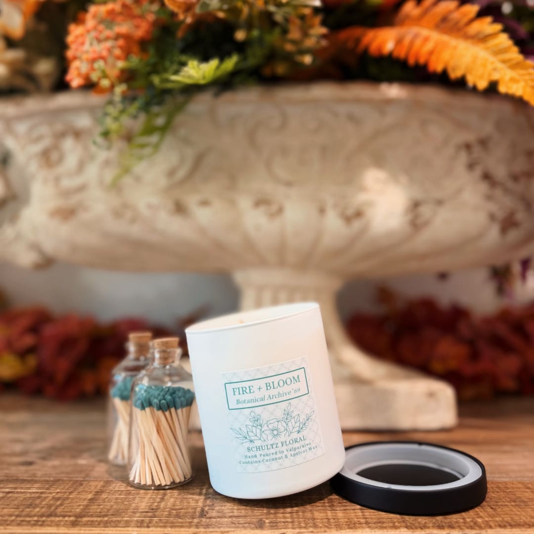 White candle jar with matches on a wooden table