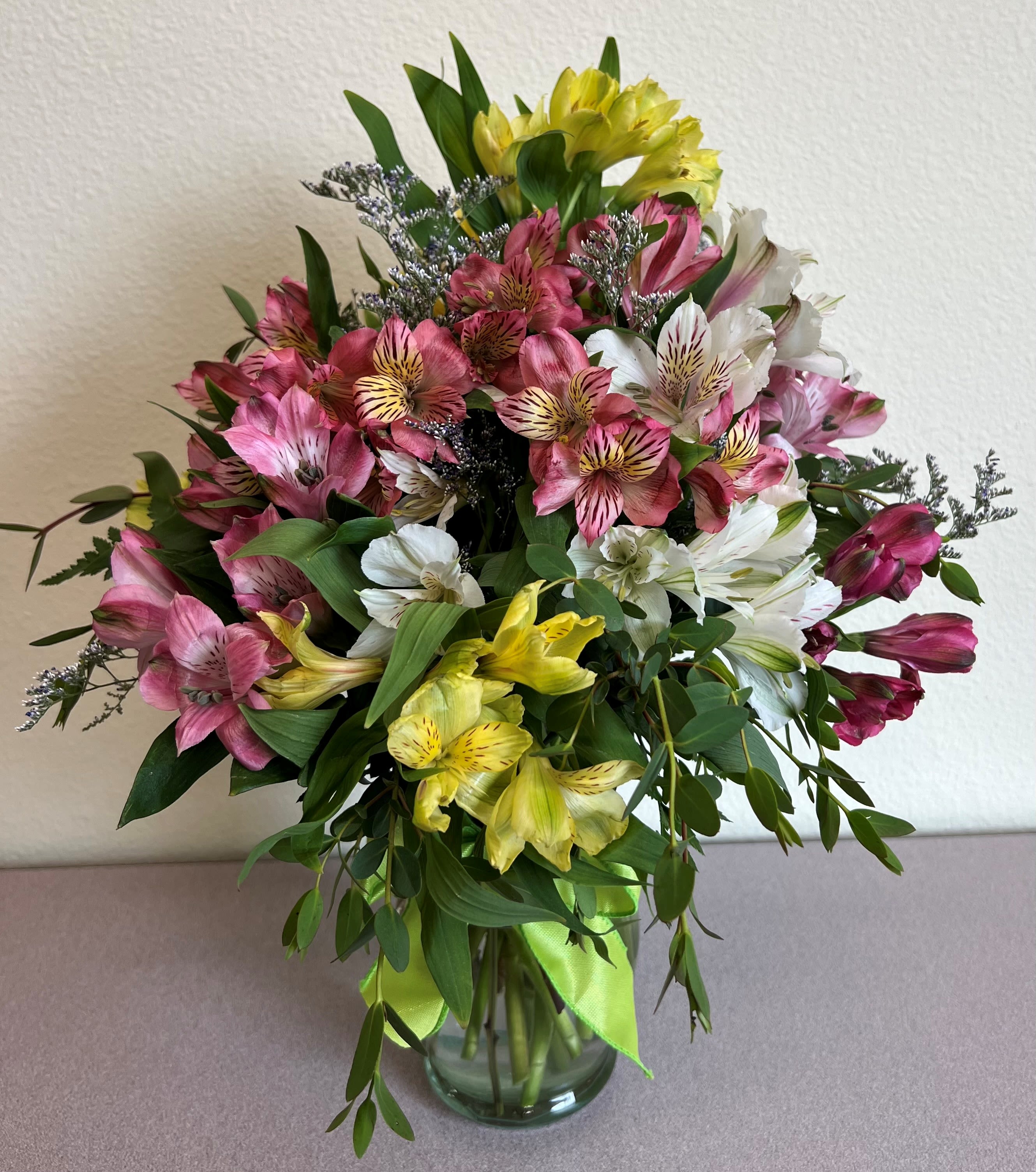 Bouquet of pink, white, and yellow alstroemeria in a glass vase