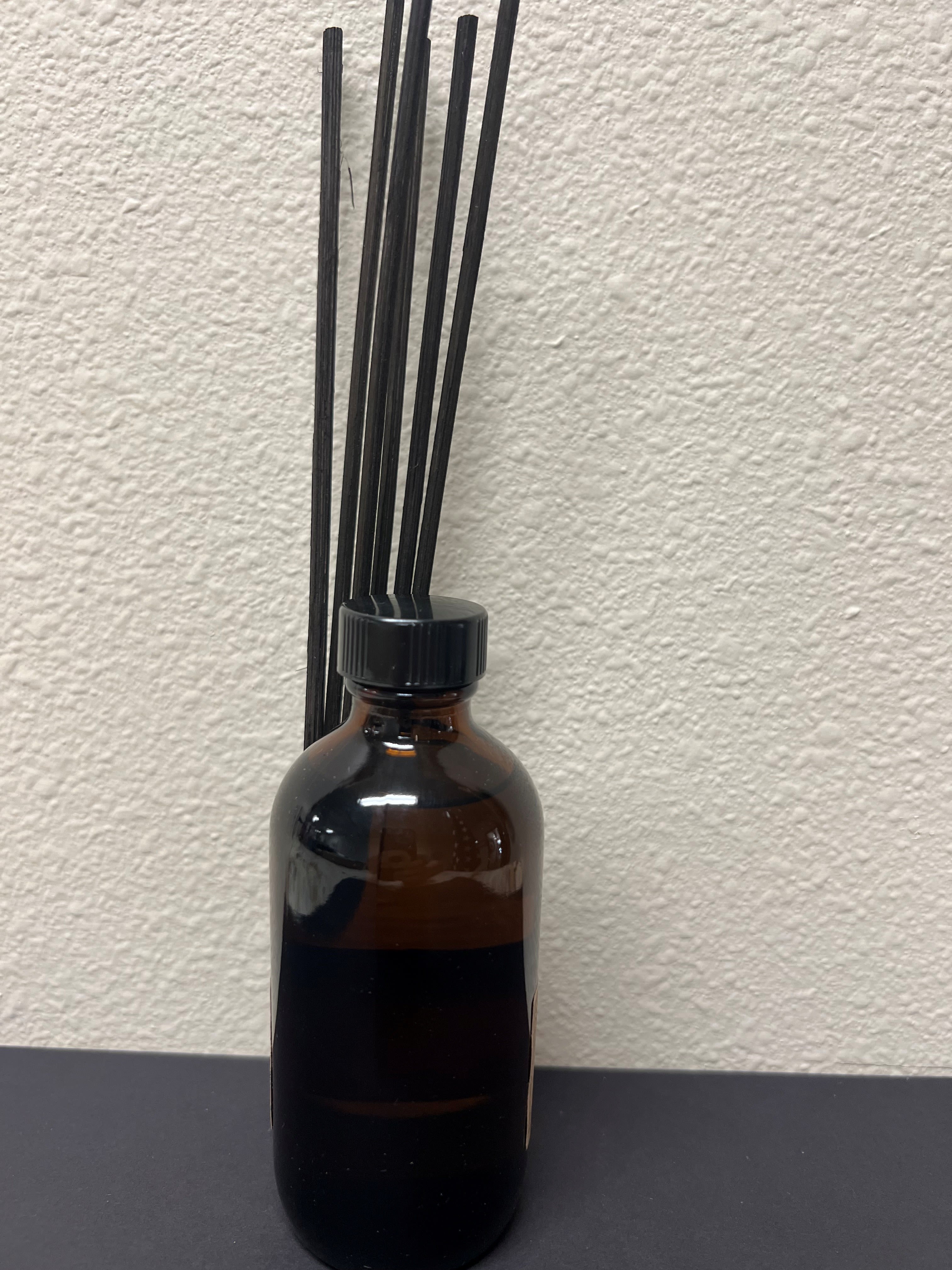 Amber glass bottle with black reed sticks