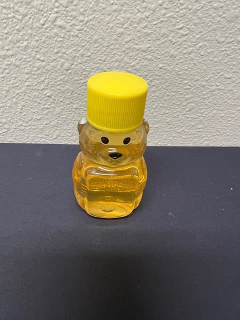 Small bear-shaped honey bottle with a yellow cap