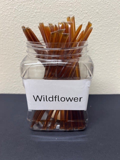 Clear jar filled with brown sticks labeled Wildflower