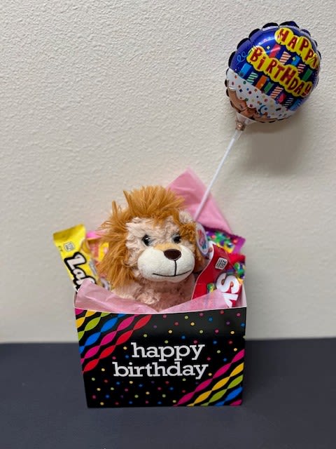 Birthday gift bag with a plush lion, candy, and a balloon