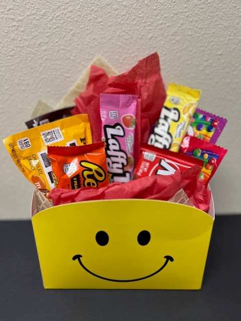 Candy assortment in a yellow smiley-face gift box