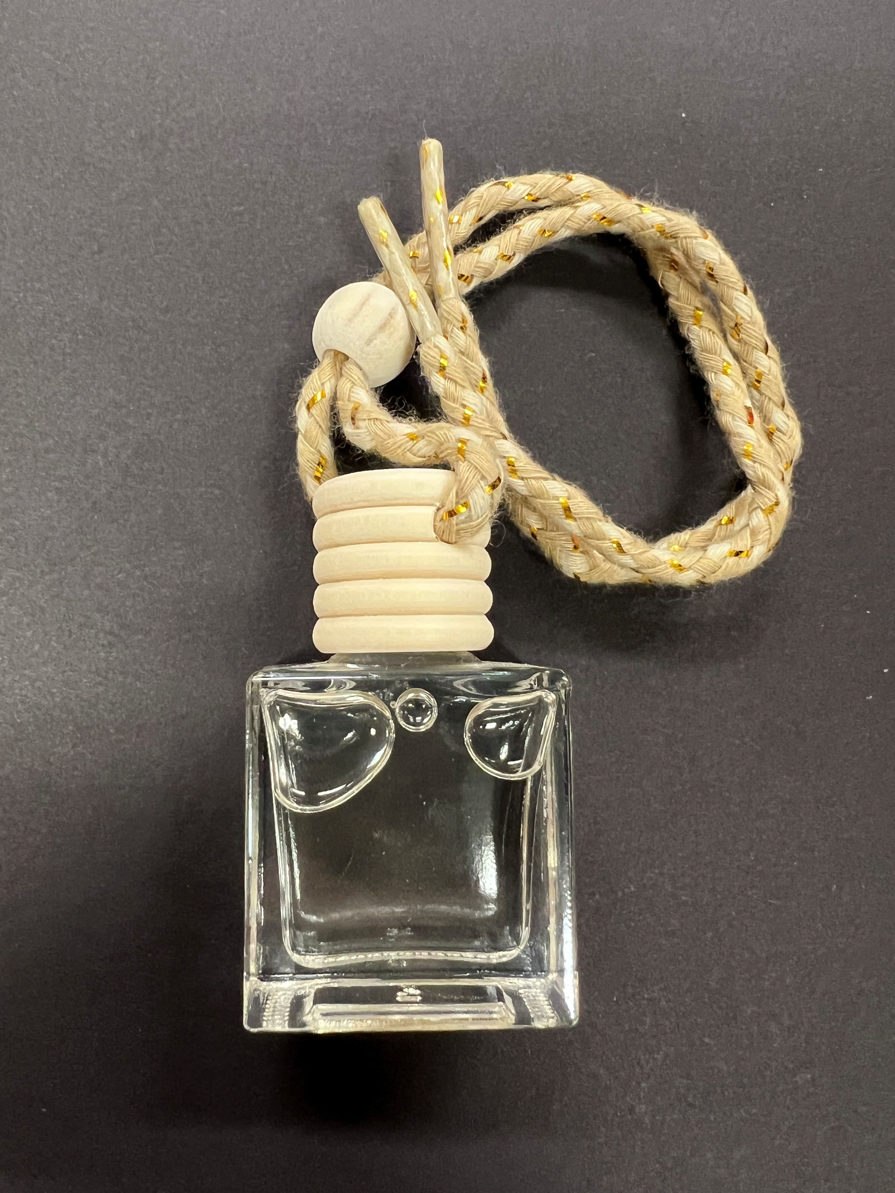 Clear glass car air freshener bottle with a braided hanging cord