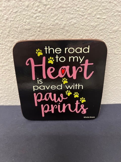 Black sign with pink text and yellow paw prints