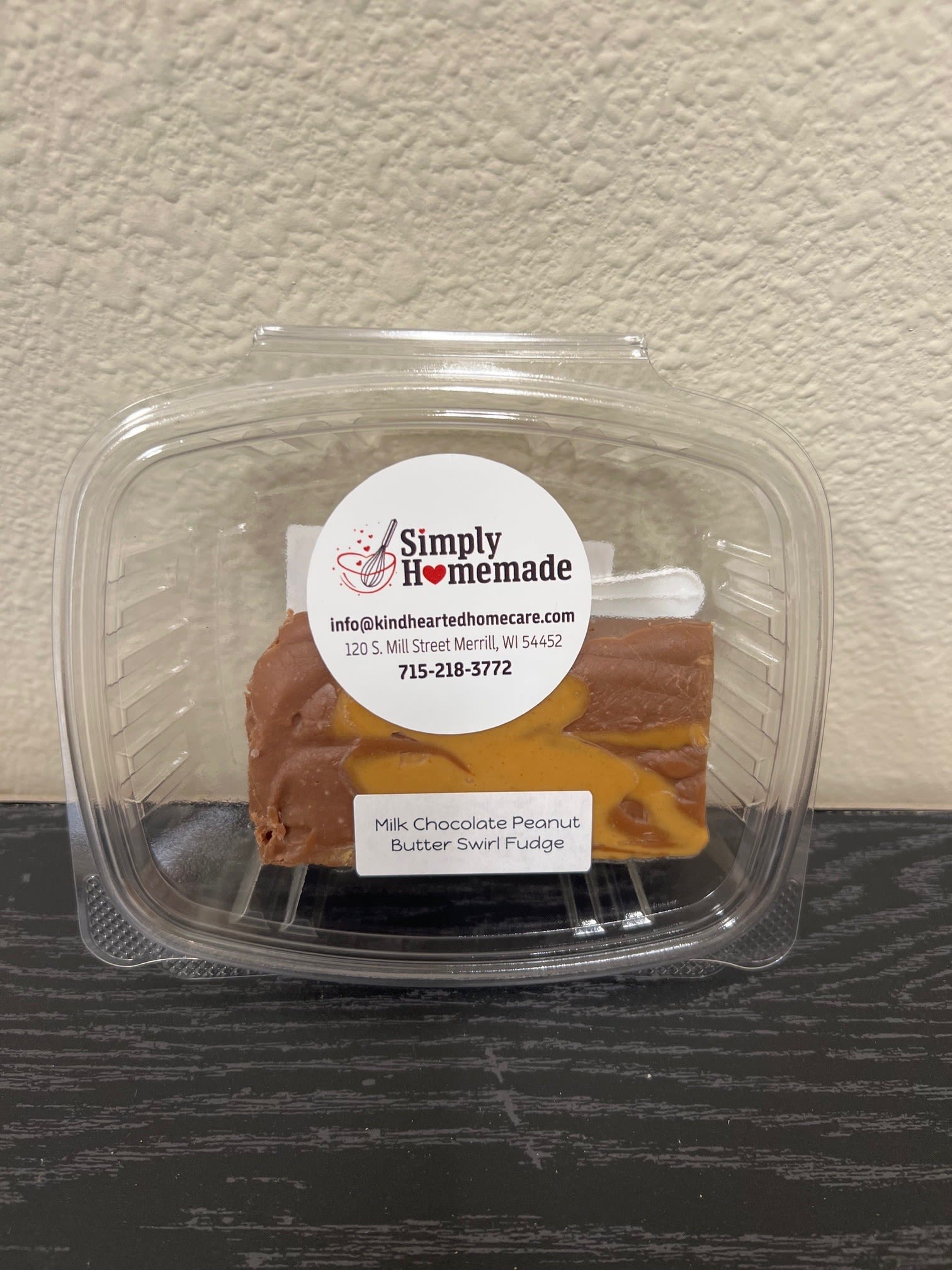Plastic clamshell container holding milk chocolate peanut butter swirl fudge