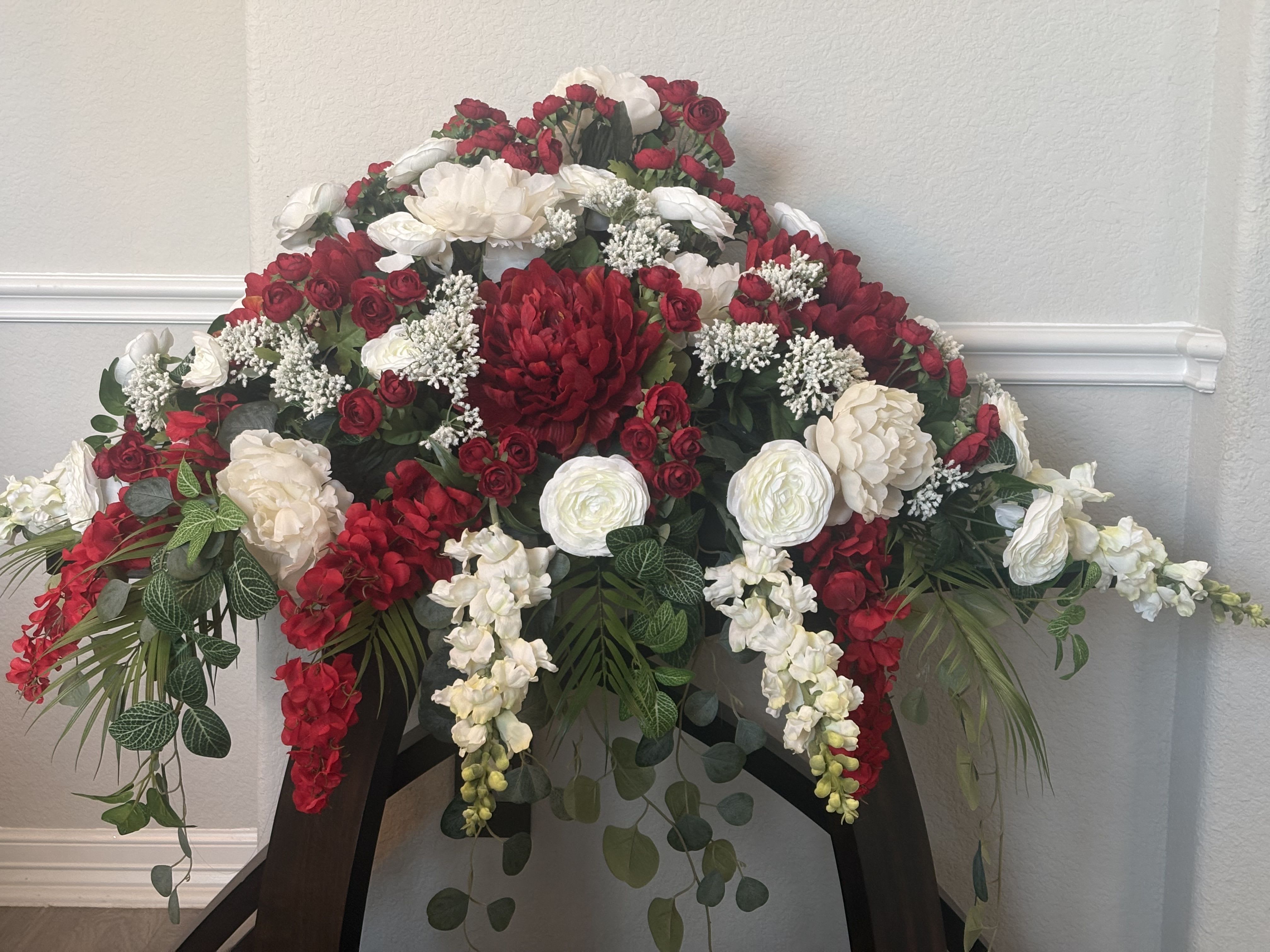 Strength and Wisdom Silk Casket Spray - This is a silk arrangement, a dramatic contrast of brilliant red and tranquil white flowers, expresses the range of emotions coloring the memorial experience, offering consolation and hope for the future to loved ones, family and friends