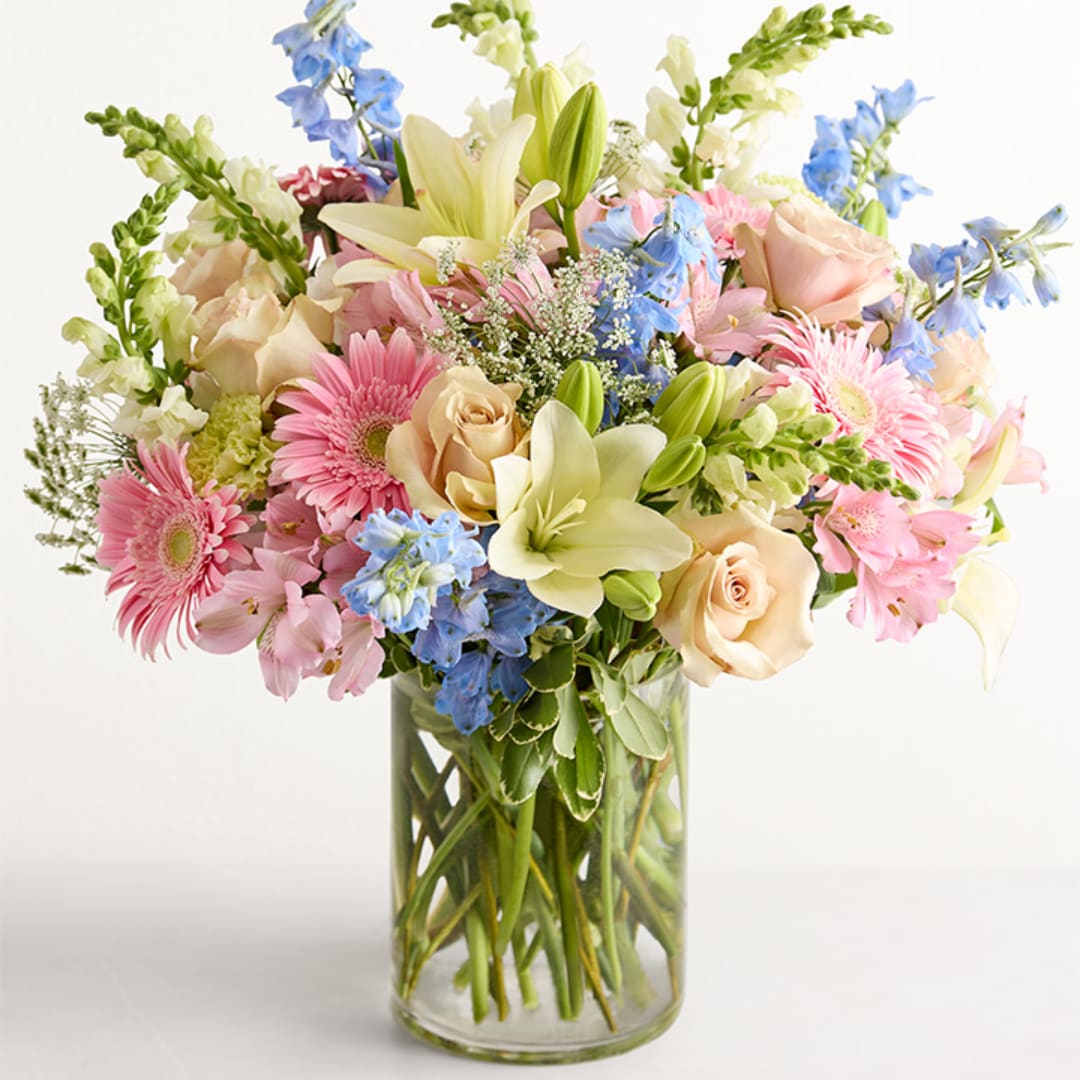 Mixed bouquet of pastel flowers in a clear glass vase
