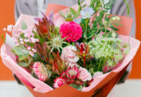 Mixed bouquet with pink and green flowers wrapped in pink paper