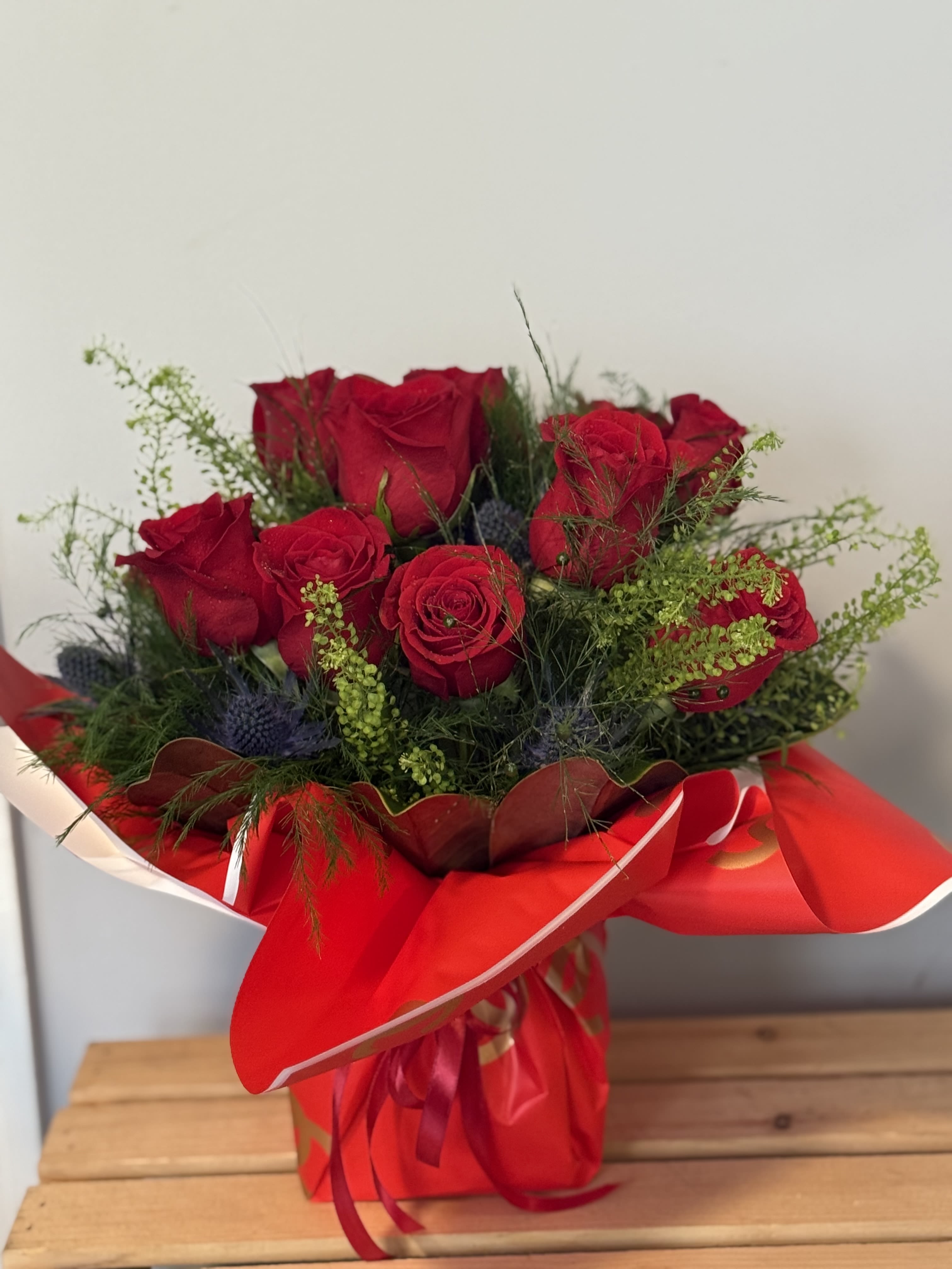 Bouquet of red roses wrapped in red paper