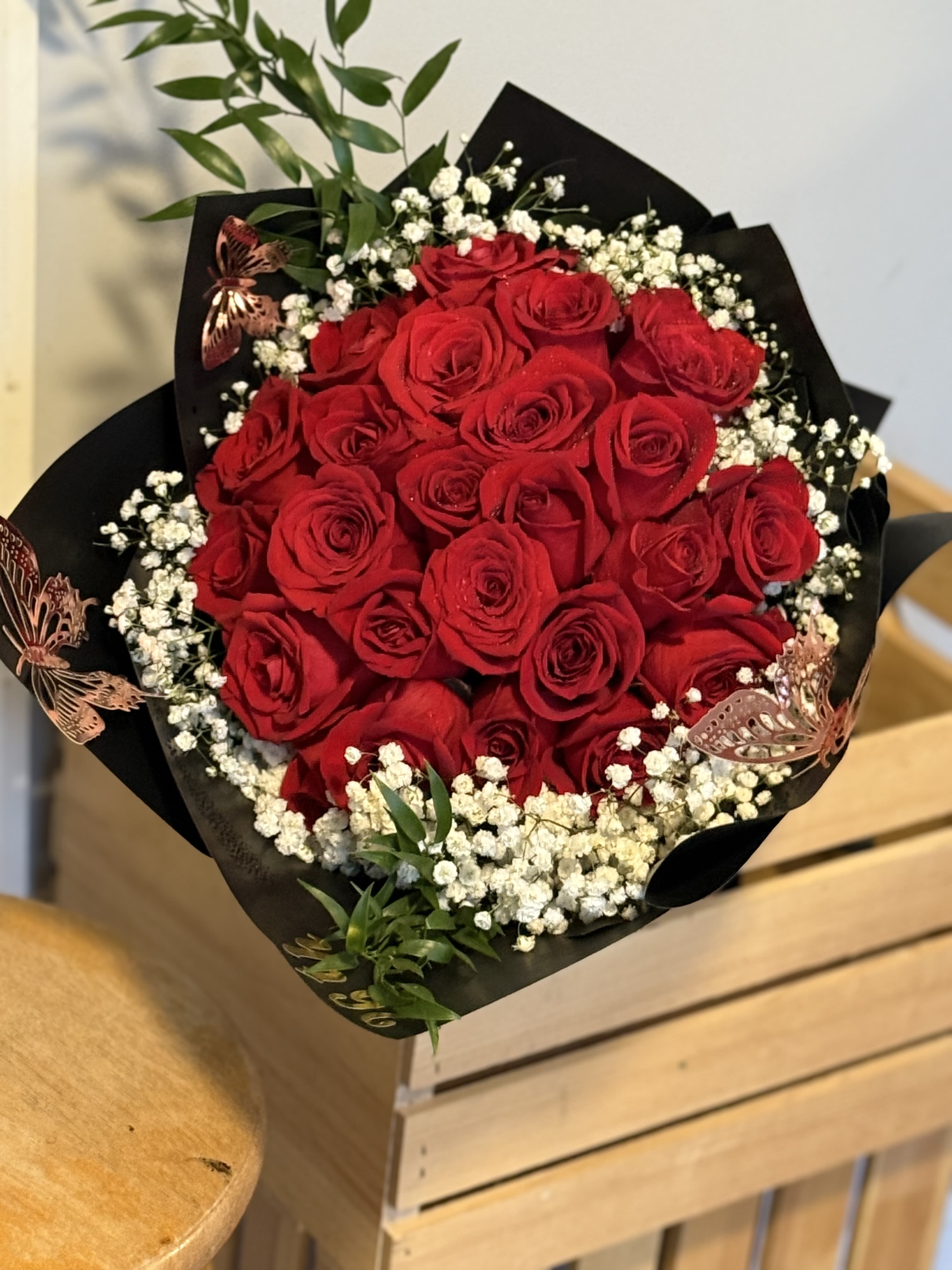 Bouquet of red roses with baby's breath in black wrapping