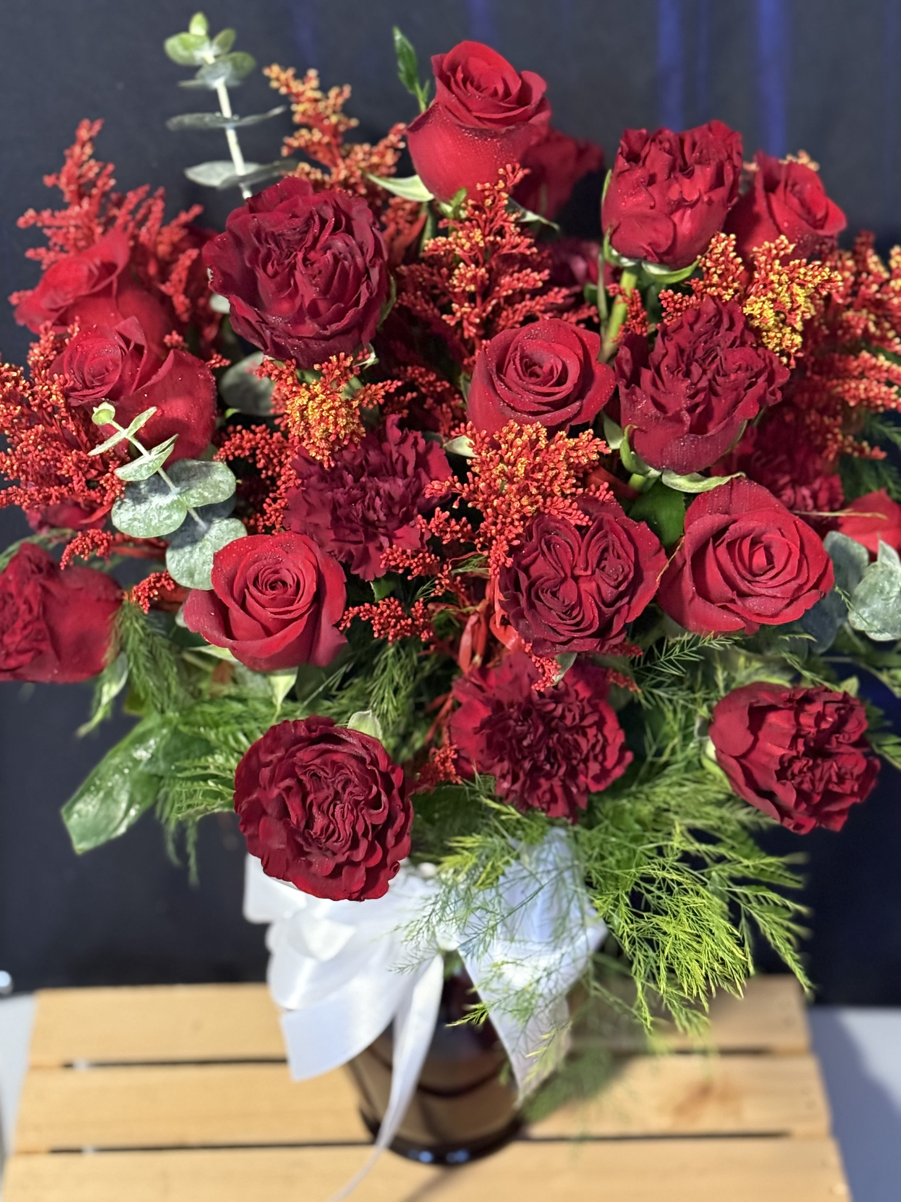 Bouquet of red roses and burgundy blooms in a vase
