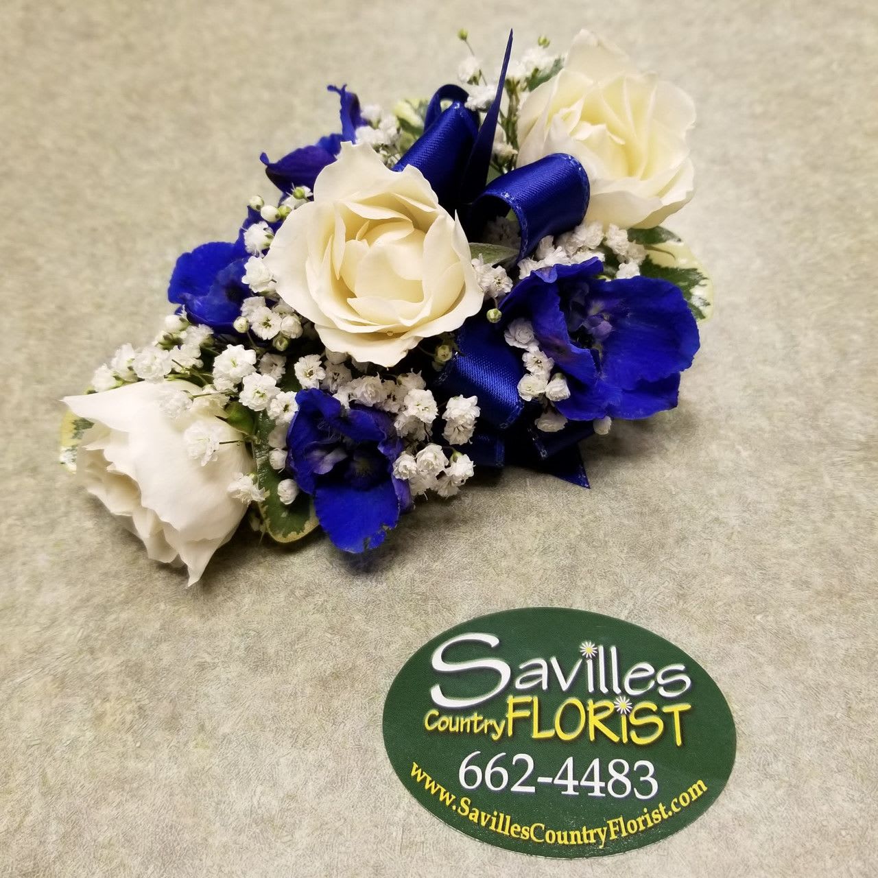 Blue and white rose corsage with ribbon and baby's breath