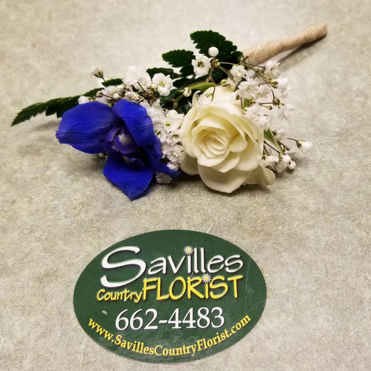 White rose and blue orchid boutonniere with baby's breath