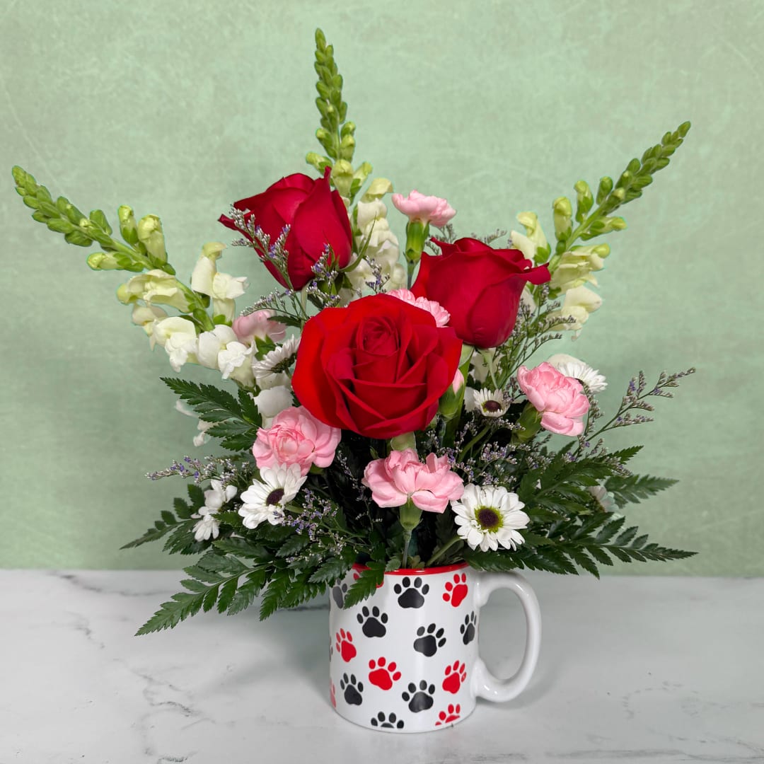 Red roses and pink carnations in a paw-print mug