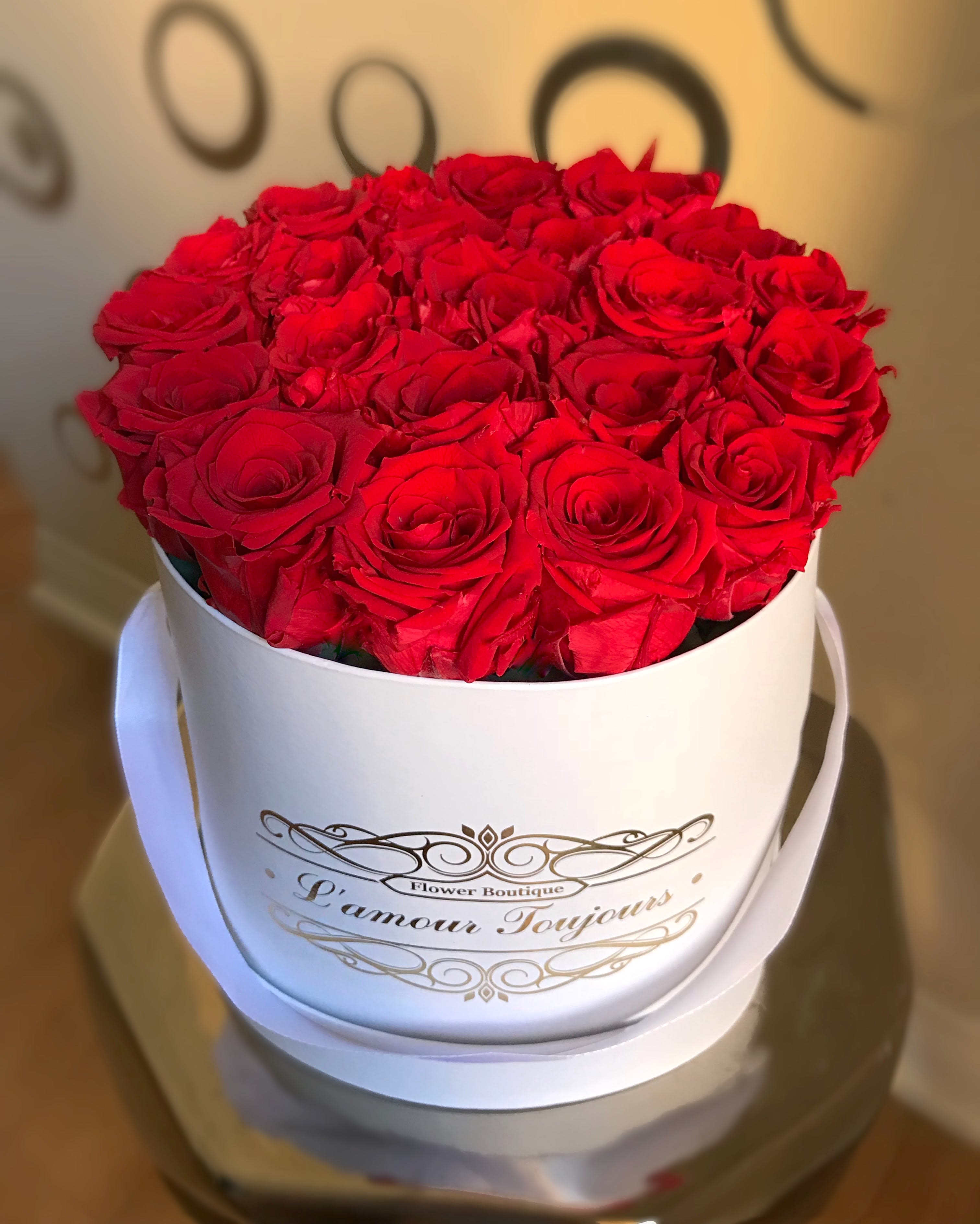 Red roses arranged in a white round hat box