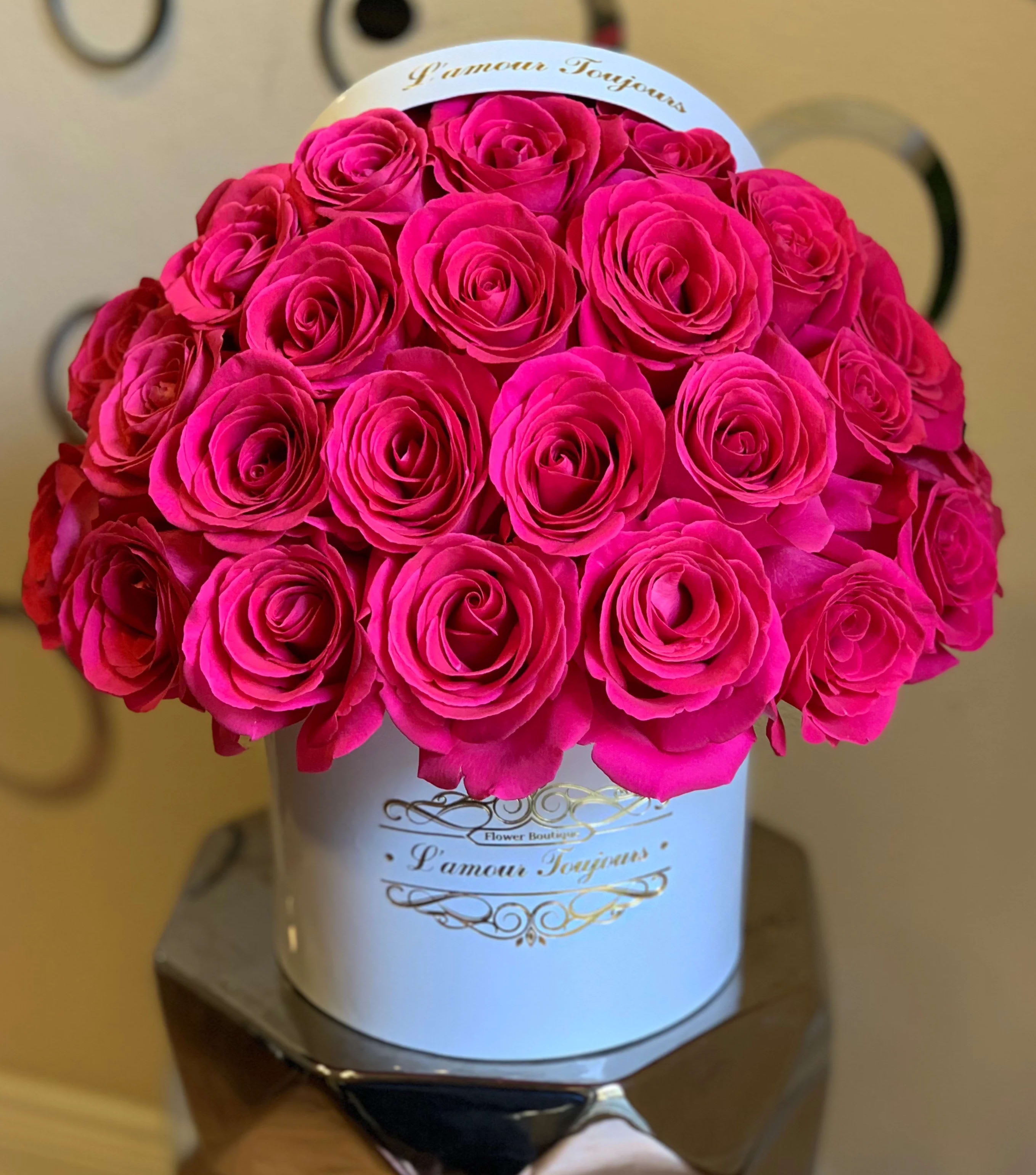 Hot pink roses arranged in a white hatbox