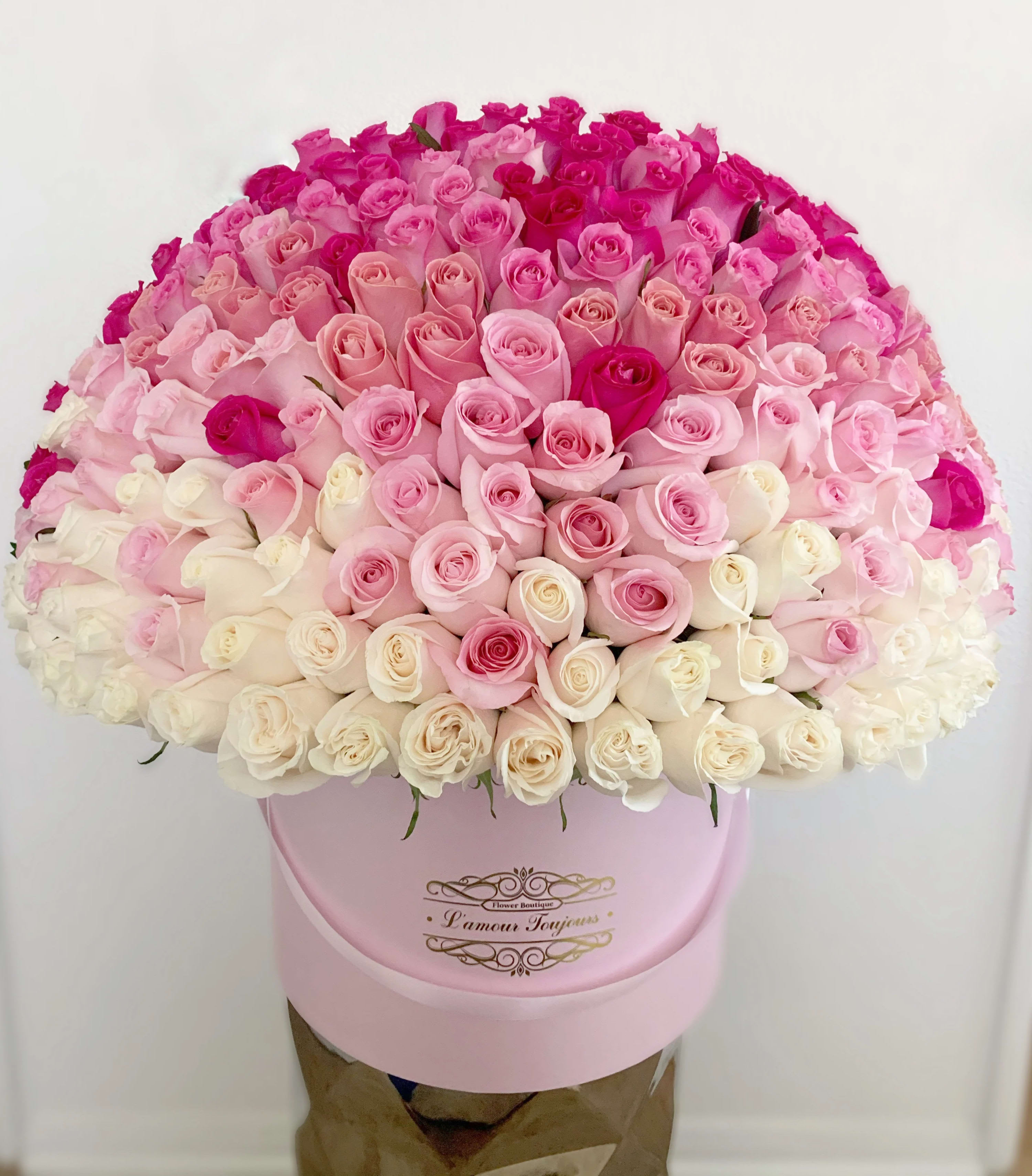 Large bouquet of pink and white roses in a pink hat box