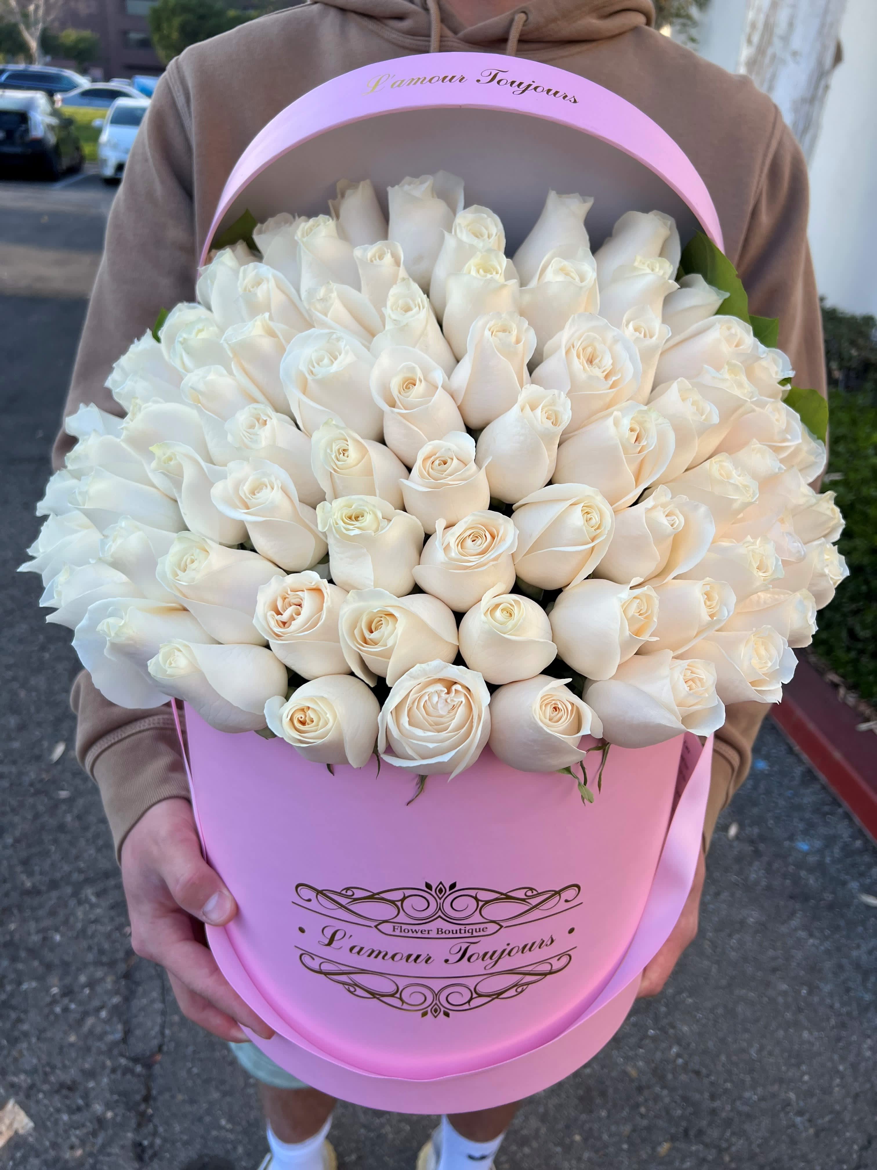 Large bouquet of white roses in a pink hatbox