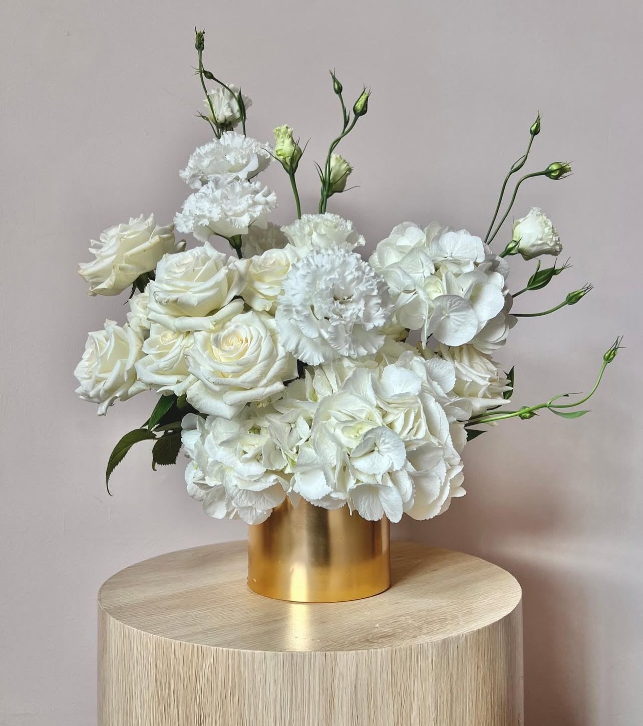 Golden Radiance - "Golden Radiance" is a sophisticated floral arrangement that effortlessly blends modern minimalism with luxurious elegance. Pristine white blooms are artfully arranged in a premium gold vase, creating a striking contrast that exudes refined taste and understated opulence.  The perfect centerpiece for any modern setting.