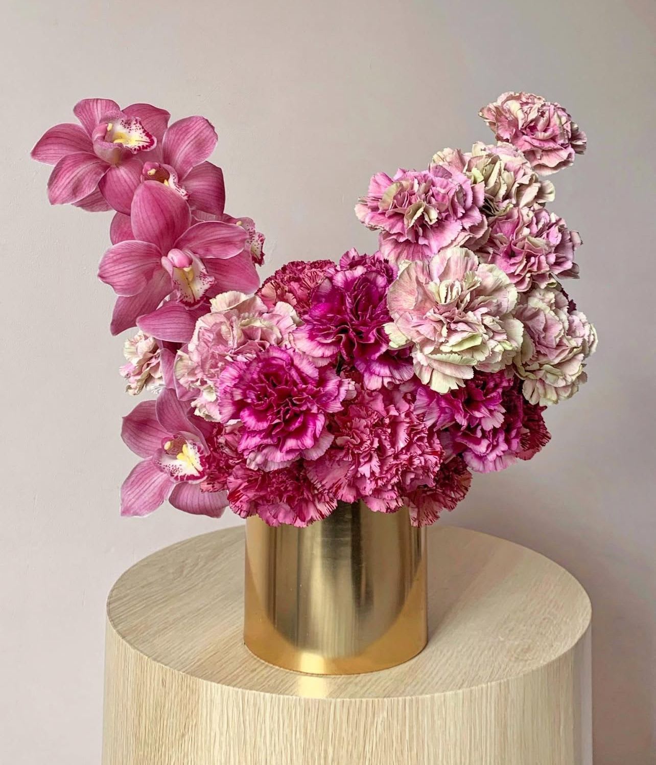 Textured Pink -  "Textured Pink" explores the interplay of textures and tones in a modern floral design.  This sophisticated arrangement contrasts the delicate petals of pink carnations with the smooth, elegant lines of pink cymbidium orchids, creating a visually captivating and texturally rich centerpiece.