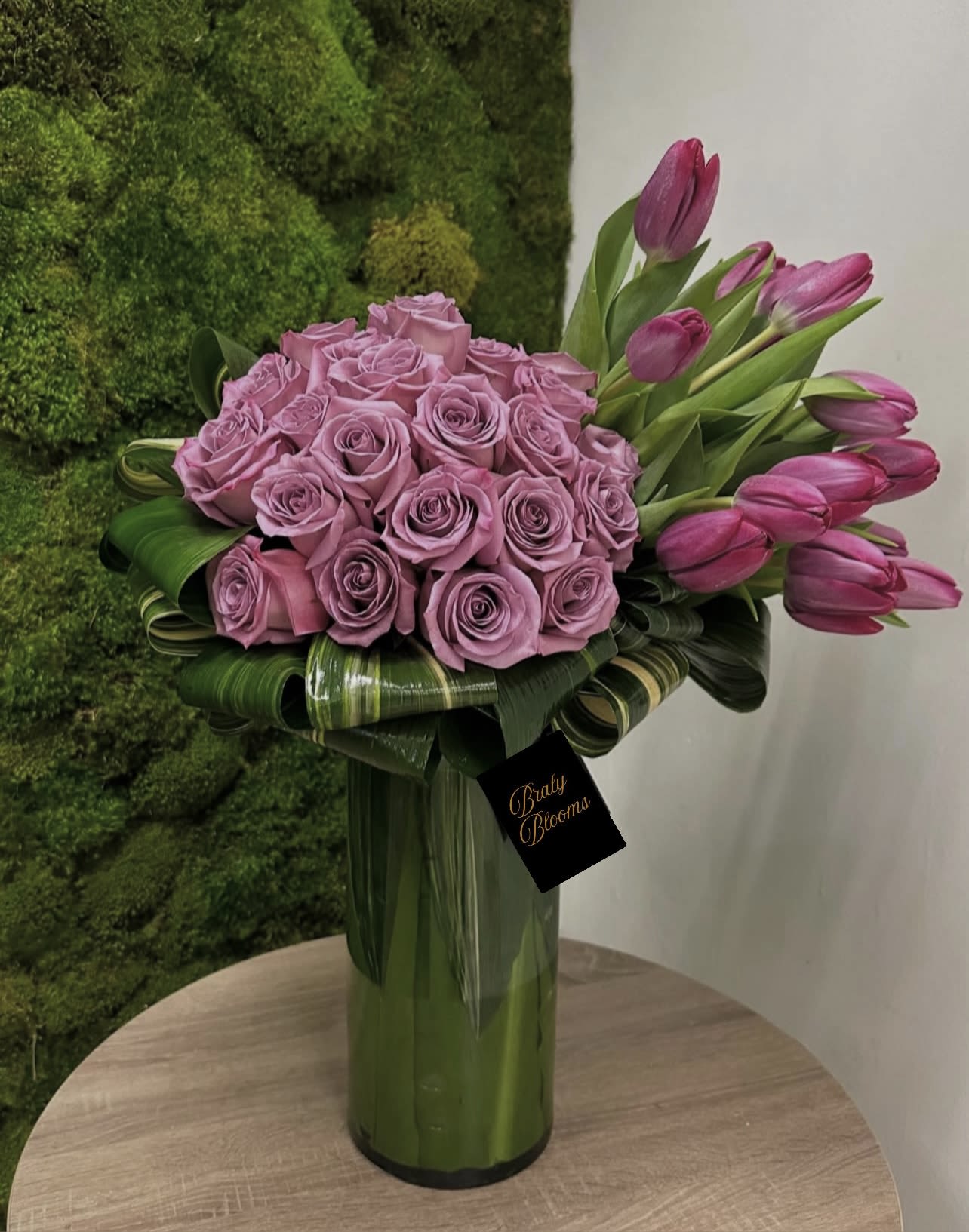 Purple Majesty - "Purple Majesty" exudes opulence and sophistication.  Rich purple roses and elegant purple tulips are artfully arranged to create a luxurious and unforgettable floral display.  The combination of rich textures and deep hues makes this a truly majestic centerpiece.