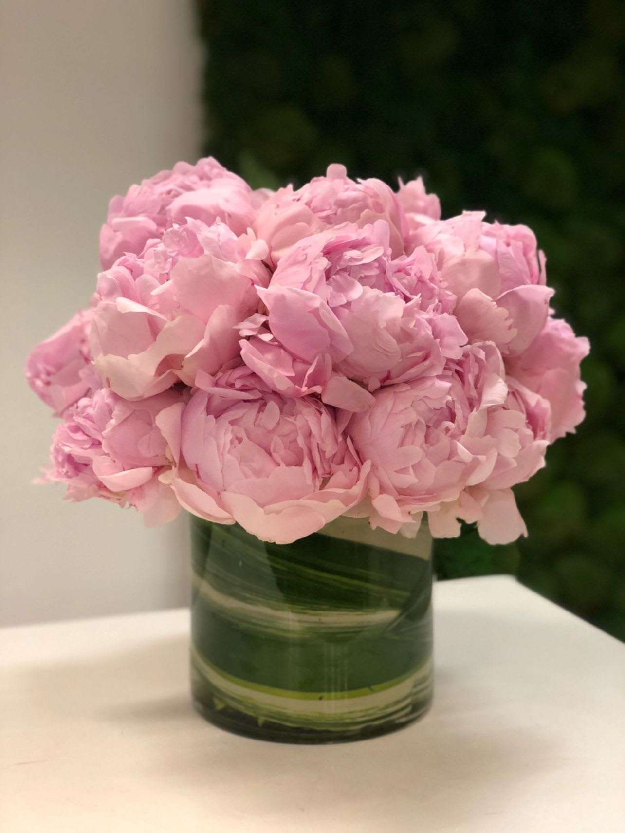 Pink peonies arranged in a green glass vase